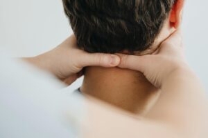 Close-up of a therapist massaging a patient's neck for pain relief and relaxation.